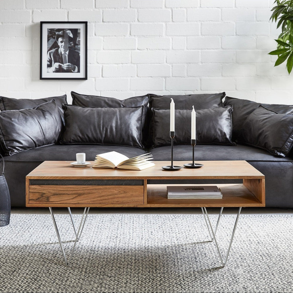 A low height, solid wood sheesham coffee table in a honey oak finish, with a minimalist design, placed in a living room setting.