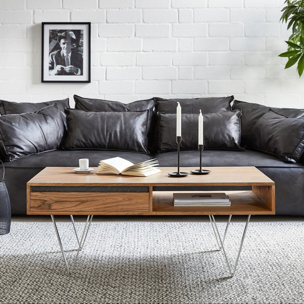 A low height, solid wood sheesham coffee table in a honey oak finish, with a minimalist design, placed in a living room setting.